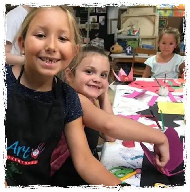 A group of children sitting at a table with paper.