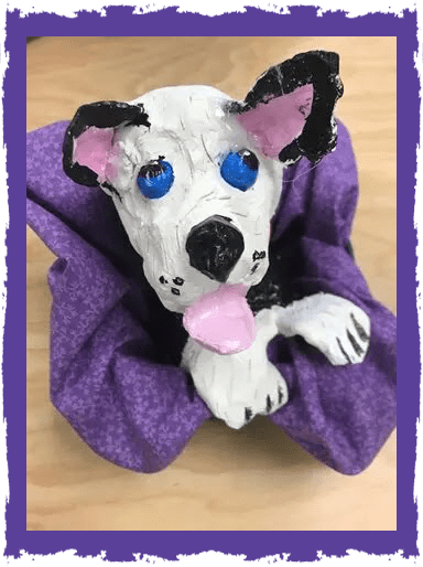 A dog is laying on top of a purple cloth.