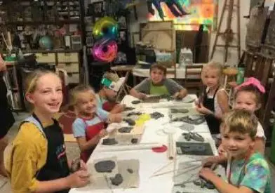 A group of children sitting at a table with rocks.