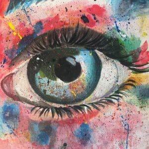 A close up of an eye with colorful paint splashing all over it.